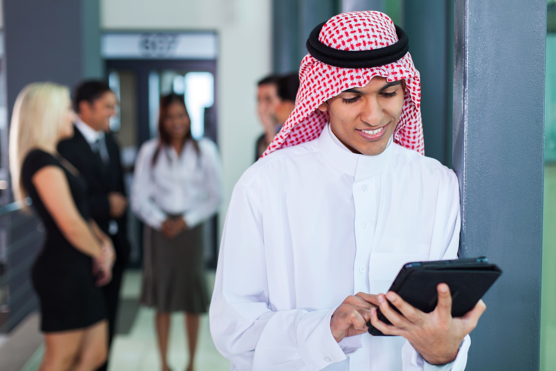 saudi arabian businessman using tablet computer