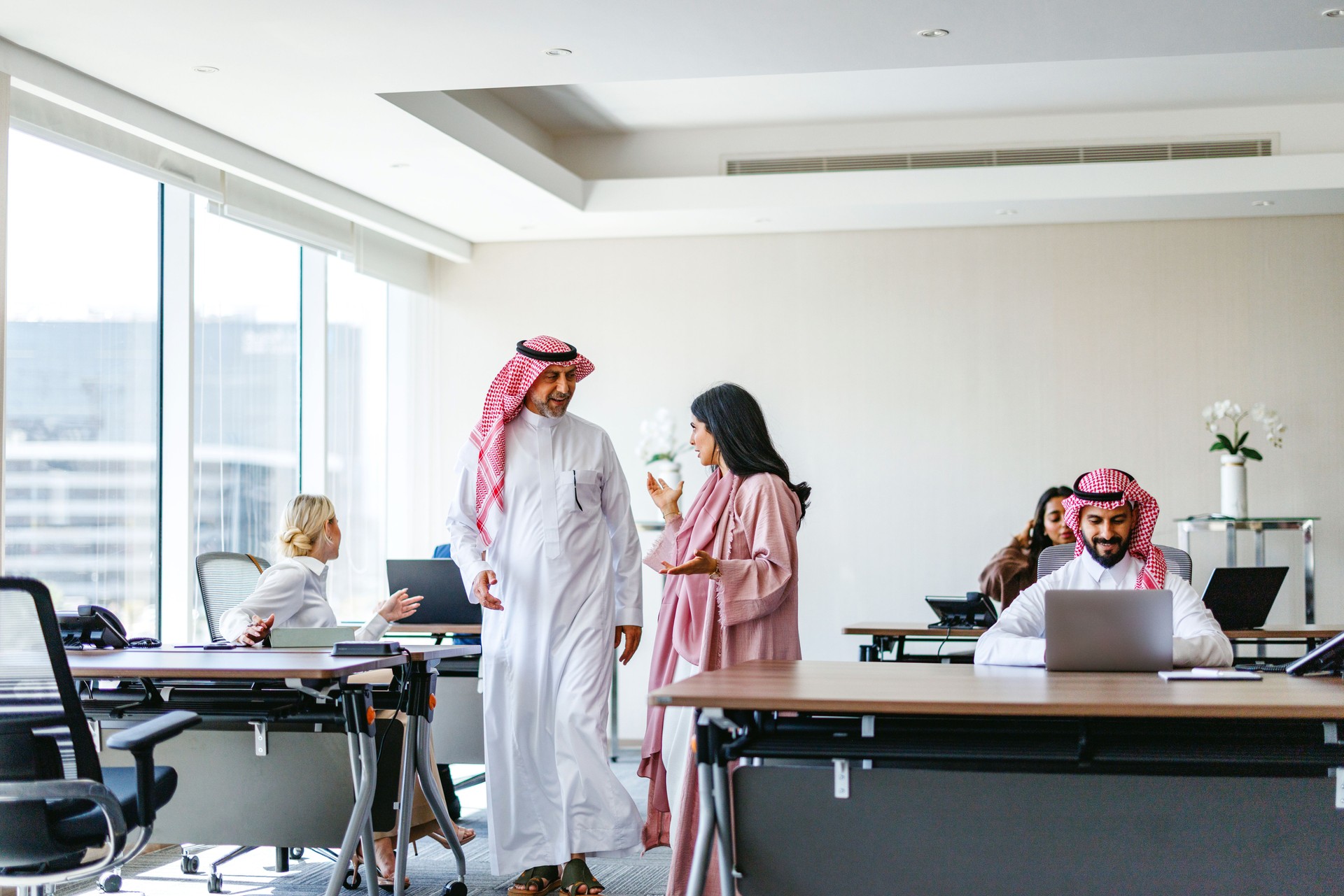 Arabic Businessman Mentoring Middle Eastern Woman in Collaborative Workspace